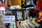 A vendor sits at her stall inside a market, in Dong Dang township