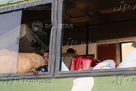 Displaced people leave a camp following a drone strike in Ad-Damar