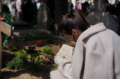 People queue up at a tomb bearing the flag with the insignia of the Iron Guard, in Bucharest