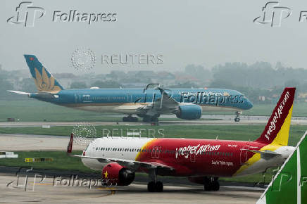 An airplane of VietJet airline and Vietnam Airlines airplane taxi at Noi Bai International Airport in Hanoi