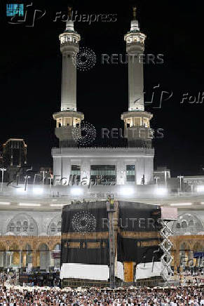 Workers change the Kabaa's cover, known as Kiswa, in the grand mosque in the holy city of Mecca