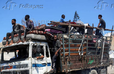 Displaced Palestinians make their way as they flee amid an Israeli military operation, in Gaza City