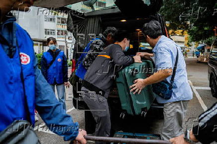 Hong Kong residents affected by the fire gather their belongings from their apartments