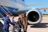 Homeland Security Secretary Kristi Noem, right, shakes hands with staff members before departing Pratica di Mare Air Base near Rome