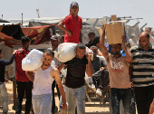 Palestinians carry aid supplies they received from the U.S.-backed Gaza Humanitarian Foundation, in Khan Younis