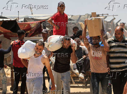 Palestinians carry aid supplies they received from the U.S.-backed Gaza Humanitarian Foundation, in Khan Younis