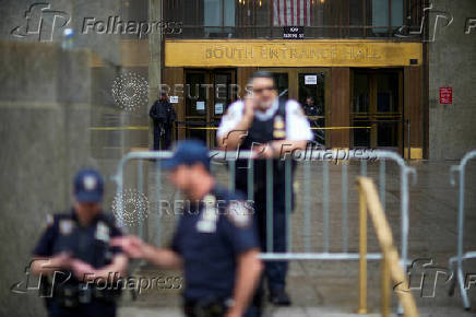 Police officers stand guard outside the Manhattan Criminal Court in New York