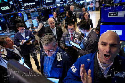 FILE PHOTO: Traders work on the floor of the NYSE in New York