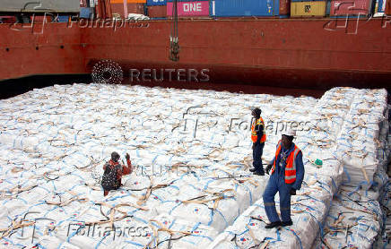Workers unload a shipment of rice from the MV Amira Sophie II, at the Kenya Ports Authority (KPA) container terminal in the port of Mombasa