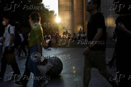 People sit on the stairs at Lujiazui financial district in Shanghai
