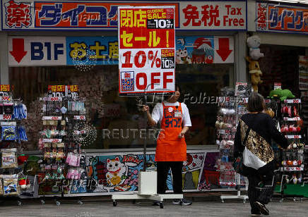 A store staff member tries to attract customers outside a store in Tokyo