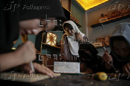Afghan girl teach Nuristani wood carving skills at a workshop in Kabul