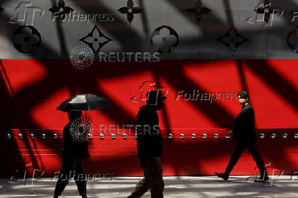 People walk in front of the new Louis Vuitton store in Shanghai