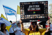 Protestors stand at the entrance to Kibbutz Nir Oz, on the day Israeli PM Netanyahu is expected to visit for the first time since the October 7, 2023 attack