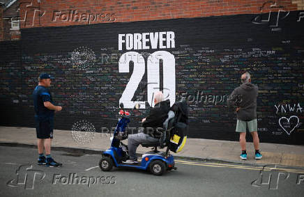 Fans look at messages written onto a memorial wall created near Anfield Stadium following the death of Liverpool soccer player Diogo Jota in Liverpool