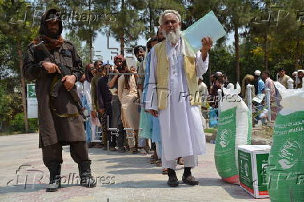 Afghan families, returned from neighboring Pakistan, receive food rations distributed by the Tawheed Charity Foundation in Jalalabad