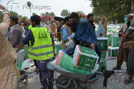 Afghan families, returned from neighboring Pakistan, receive food rations distributed by the Tawheed Charity Foundation in Jalalabad