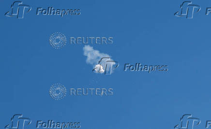 The suspected Chinese spy balloon drifts to the ocean after being shot down off the coast in Surfside Beach