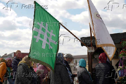 People queue up at a tomb bearing the flag with the insignia of the Iron Guard, in Bucharest