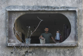 Palestinians inspect the damage at the site of an Israeli strike on a house, in Jabalia