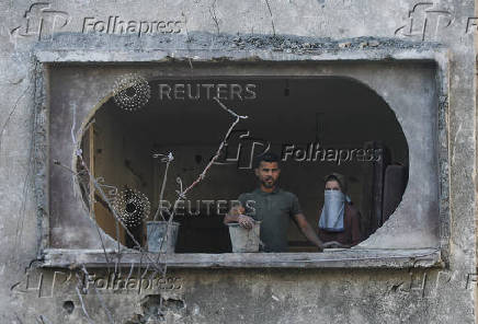 Palestinians inspect the damage at the site of an Israeli strike on a house, in Jabalia