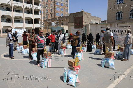 Yemenis receive food aid in Sana'a, distributed by Mona Relief agency