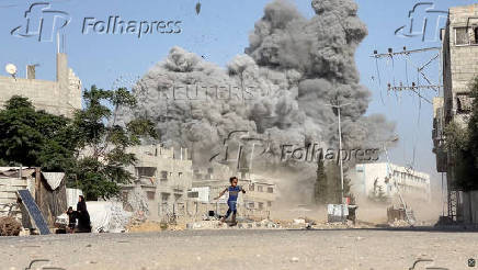 A girl runs from the scene after Israeli strikes on a school sheltering displaced people at the Bureij refugee camp in the central Gaza Strip