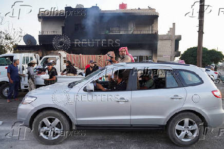 Bedouin fighters gather near a vehicle, in Sweida governorate