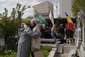 People queue up at a tomb bearing the flag with the insignia of the Iron Guard, in Bucharest