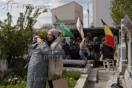 People queue up at a tomb bearing the flag with the insignia of the Iron Guard, in Bucharest