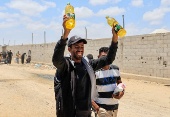 Palestinians carry aid supplies they received from the U.S.-backed Gaza Humanitarian Foundation, in Khan Younis