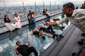 Indian tourists pose as they enjoy the Mahanakhon Skywalk Rooftop in Bangkok