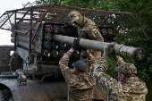 Ukrainian servicemen load a rocket into a multiple launcher before firing towards Russian troops on a front line in Zaporizhzhia region