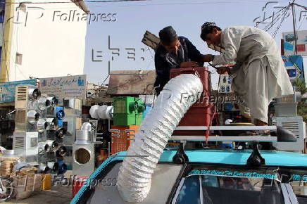 Taxi drivers install locally made air coolers to beat the heat in Kandahar