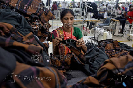 A worker makes final on shirts before packaging in a garment manufacturing unit on the outskirts of Ahmedabad