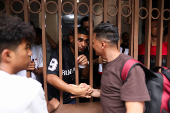 Migrants gather outside the Venezuelan embasssy waiting for a flight back to their country