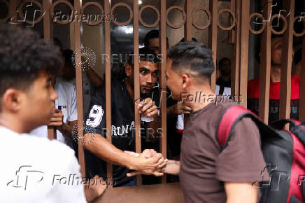 Migrants gather outside the Venezuelan embasssy waiting for a flight back to their country