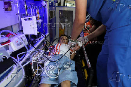 A Palestinian boy who came to Jordan through King Hussein Bridge receives medical treatment inside an ambulance in Amman