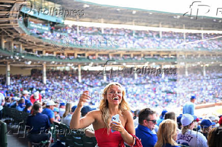 A woman reacts as baseball fans watch the Chicago Cubs and the Milwaukee Brewers at Wrigley Field in Chicago