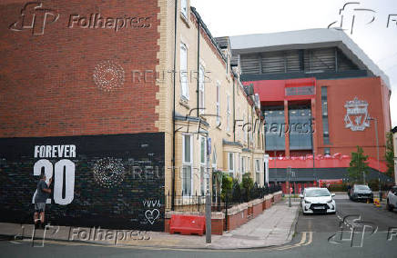 A fan adds a message to a memorial wall created near Anfield Stadium following the death of Liverpool soccer player Diogo Jota in Liverpool