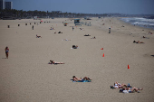 People enjoy the sun on the beach in Santa Monica