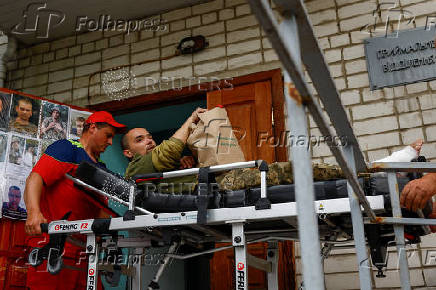 Medics assist a Ukrainian prisoner of war as he returns after a swap in an undisclosed location in Ukraine