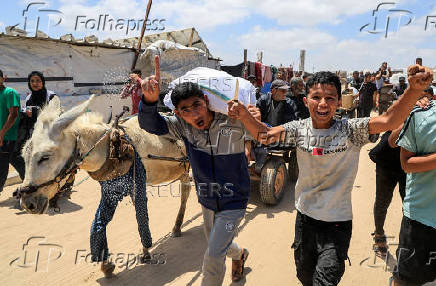 Palestinians carry aid supplies they received from the U.S.-backed Gaza Humanitarian Foundation, in Khan Younis