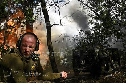 A Ukrainian serviceman fires a howitzer towards Russian troops in a front line in Zaporizhzhia region
