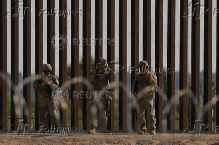 U.S. soldiers reinforce border wall with razor wire seen from Ciudad Juarez