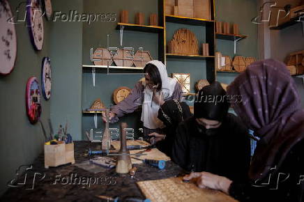 Afghan girl teach Nuristani wood carving skills at a workshop in Kabul