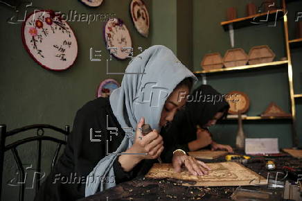 Afghan girl teach Nuristani wood carving skills at a workshop in Kabul