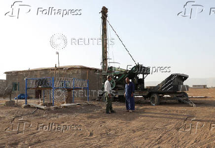 Qahraman Barakat stands in front of his house after digging a well, in Qamsihli