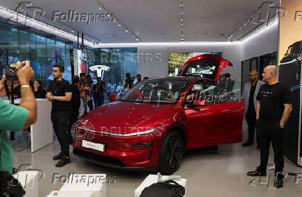 Media personnel take pictures and videos of the TESLA Model Y car at India's first Tesla showroom in Mumbai,