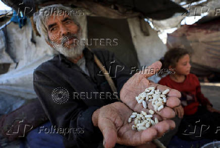Displaced Palestinians who have not received humanitarian aid survive on leftover food, in Gaza